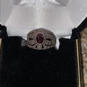 Red ruby in a size 6. Surrounded by black diamonds